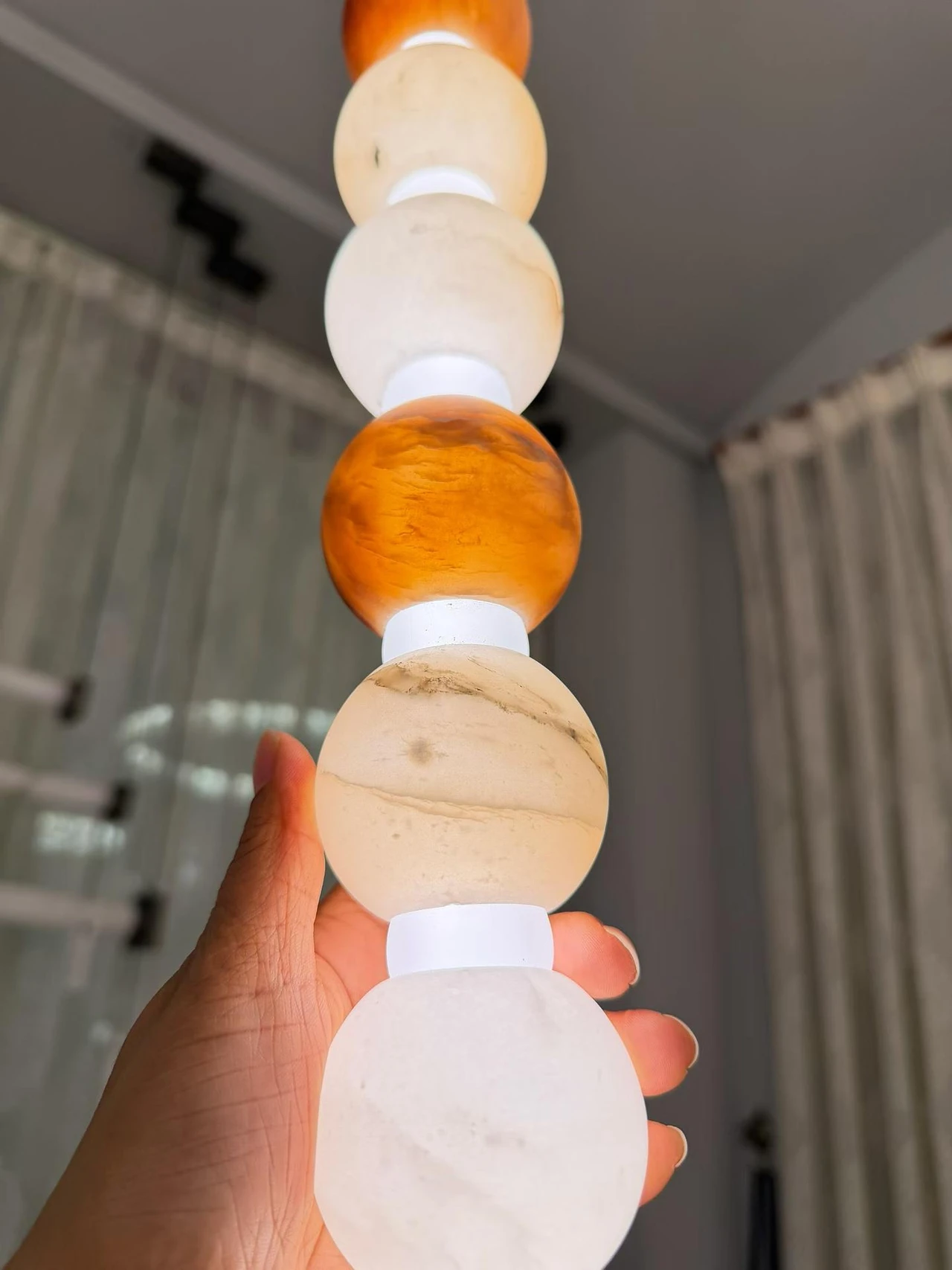 Vertical alabaster light with illuminated white and amber spheres