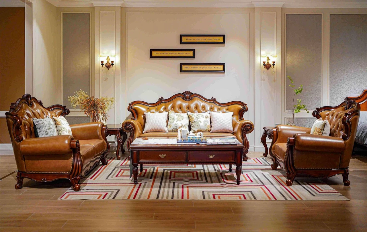 Caramel tufted sofas and armchair with ornate dark frames around a rectangular coffee table on a geometric rug