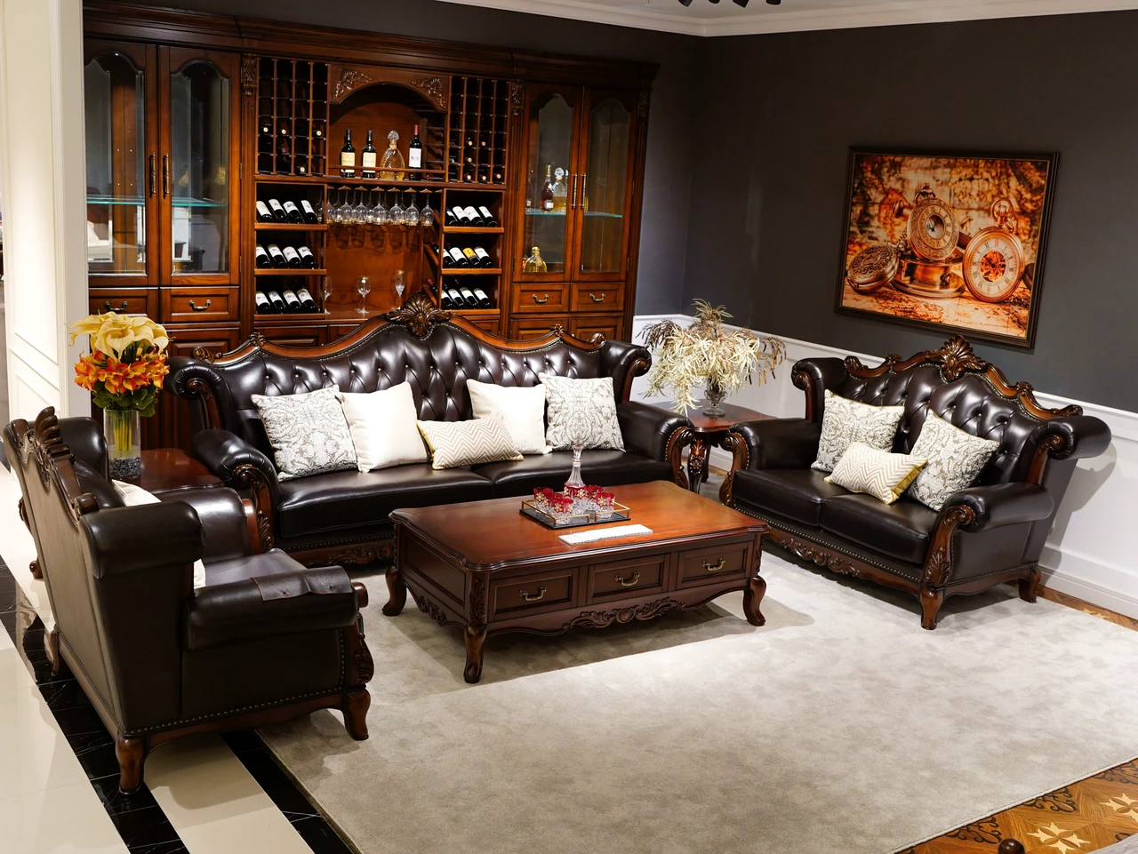 Dark tufted sofas and armchairs with carved wood-tone frames around a rectangular coffee table