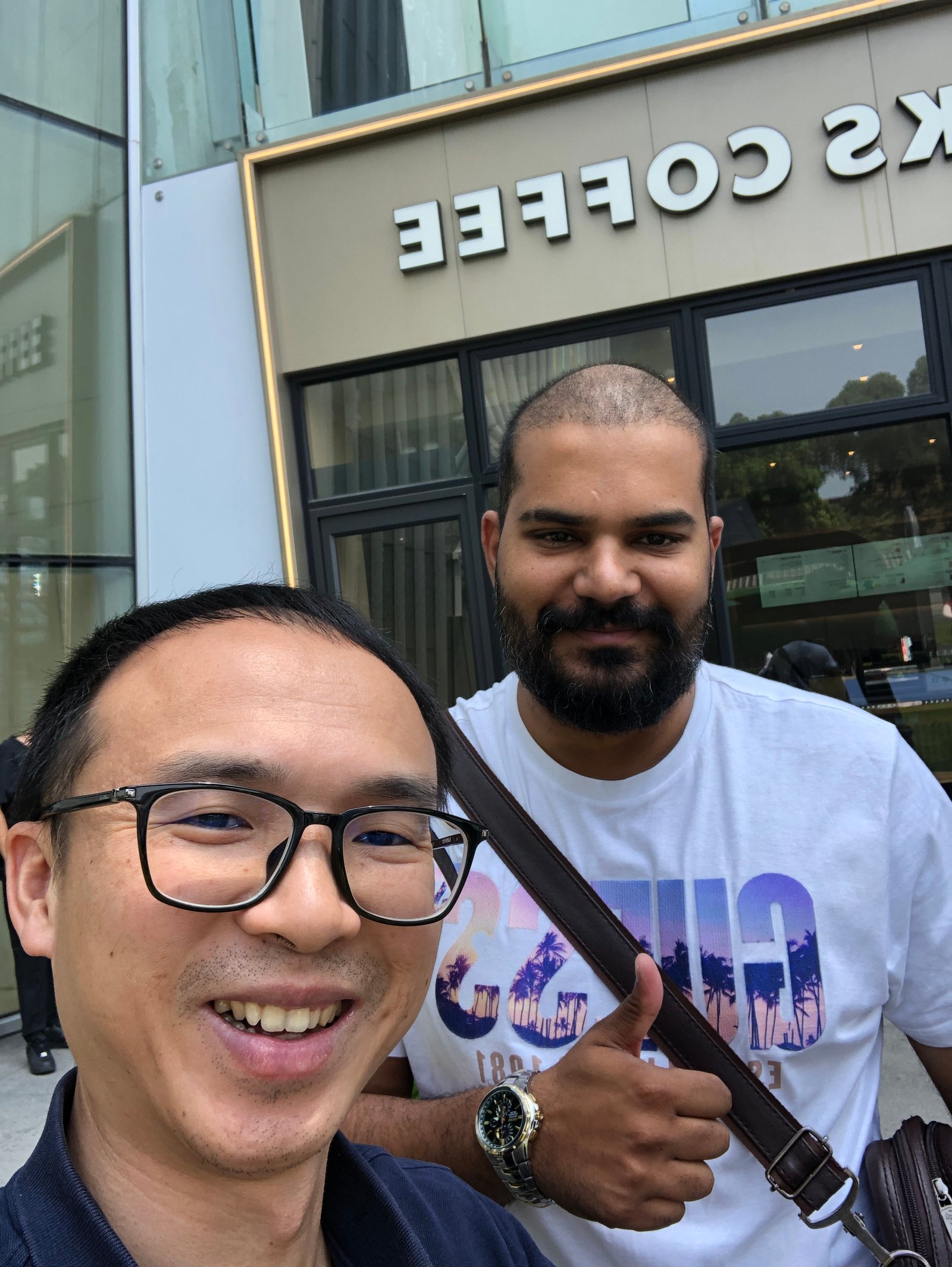 Two people outside a coffee shop during a client visit